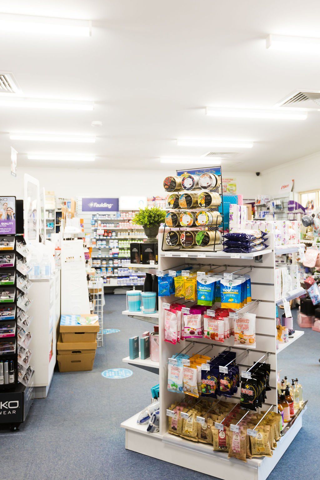 A brightly lit convenience store aisle with snack shelves and assorted packaged goods.