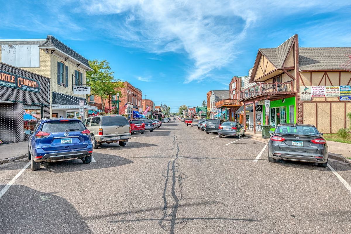 A row of cars are parked on the side of a city street.