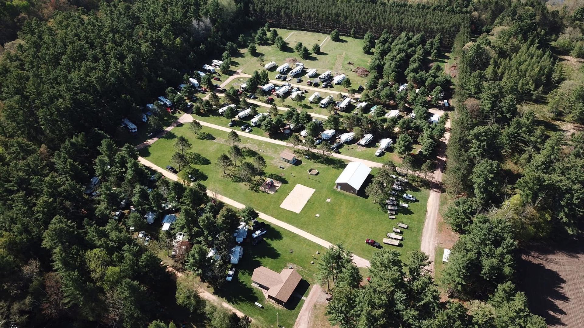 An aerial view of a campground surrounded by trees and grass.