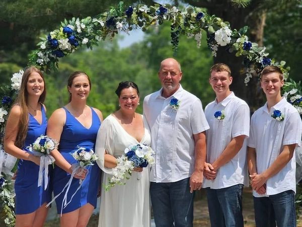 A bride and groom are posing for a picture with their wedding party.