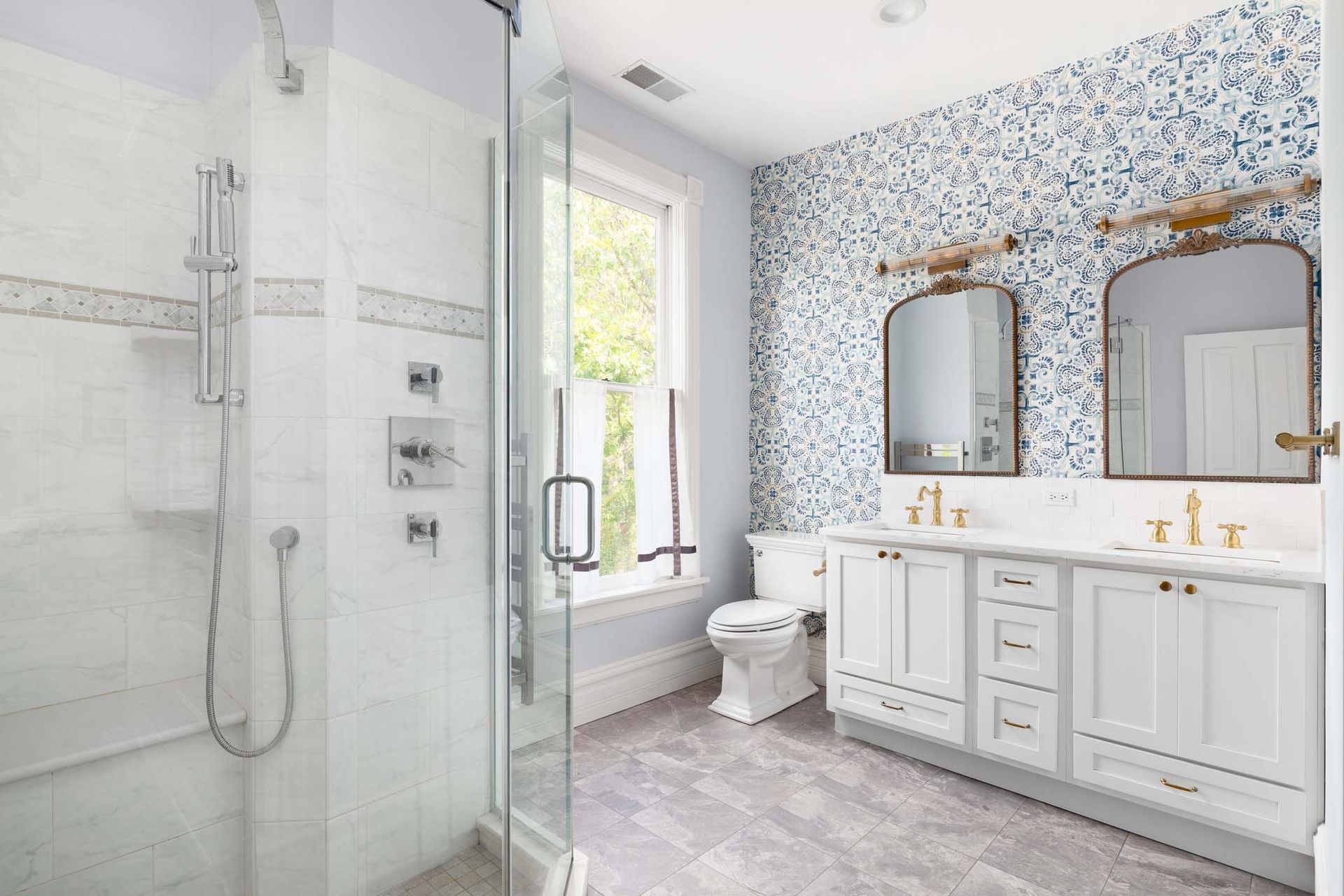 A bathroom with a walk in shower , toilet , sink and mirrors.