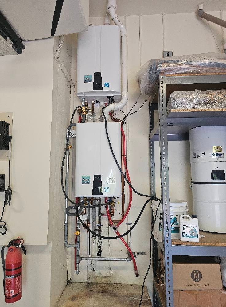 A room with a fire extinguisher and a water heater on the wall.