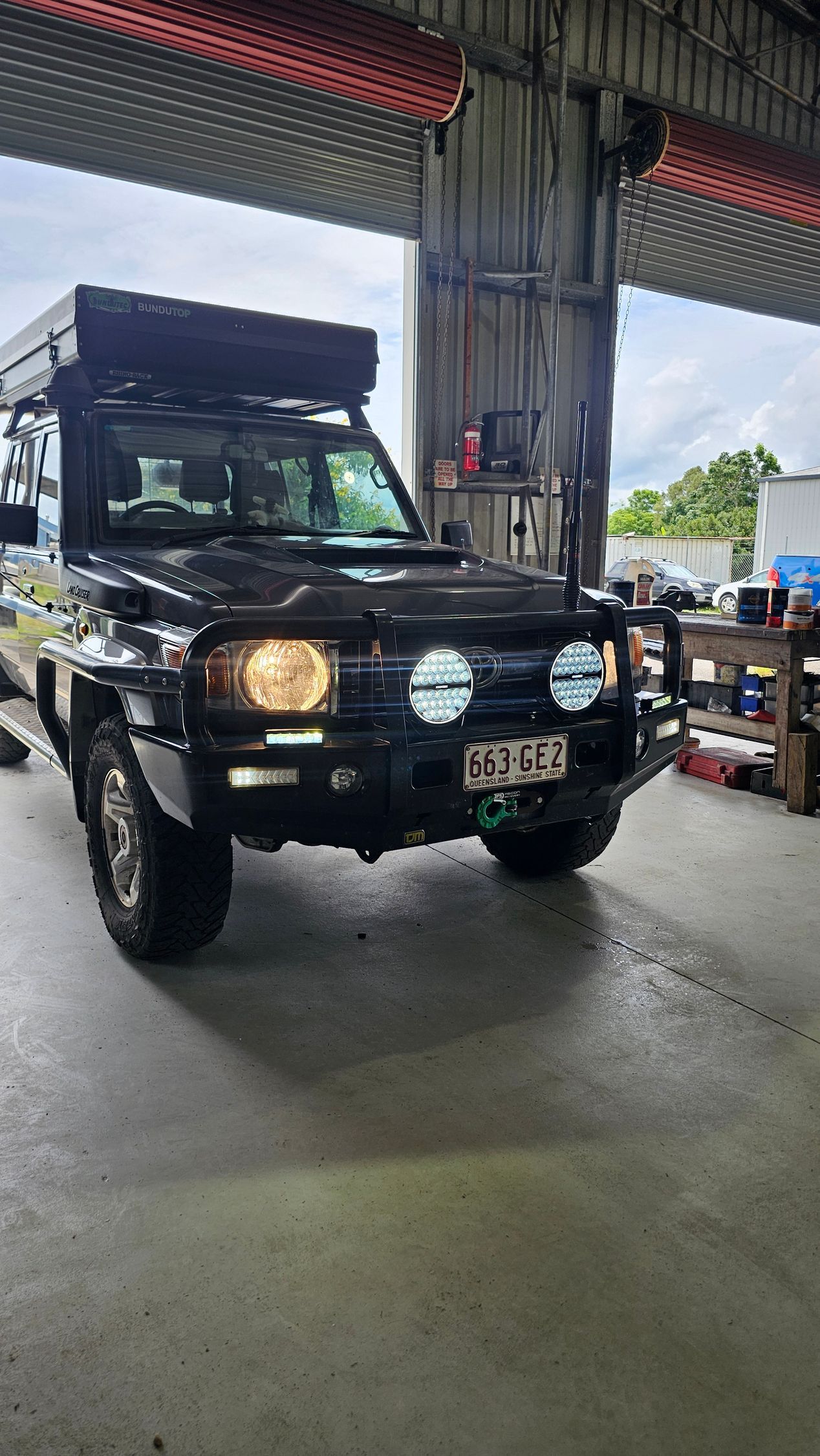 Black off-road Vehicle With Roof Tent Parked in a Garage, Illuminated by Overhead Lights — Track N Back 4x4 In Mareeba, QLD