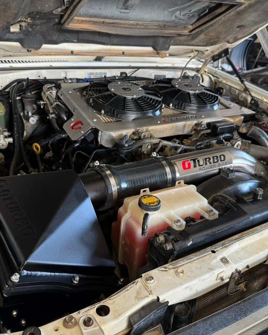 Engine Bay of a Vehicle, With a Turbocharger, Intake, and Cooling Fans Visible — Track N Back 4x4 In Mt Isa, QLD