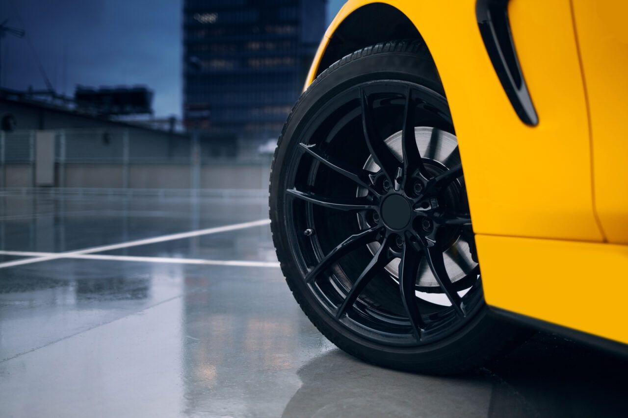 Yellow Sports Car Wheel With Black Rim on a Wet, Gray Surface — Track N Back 4x4 In Thursday Island, QLD