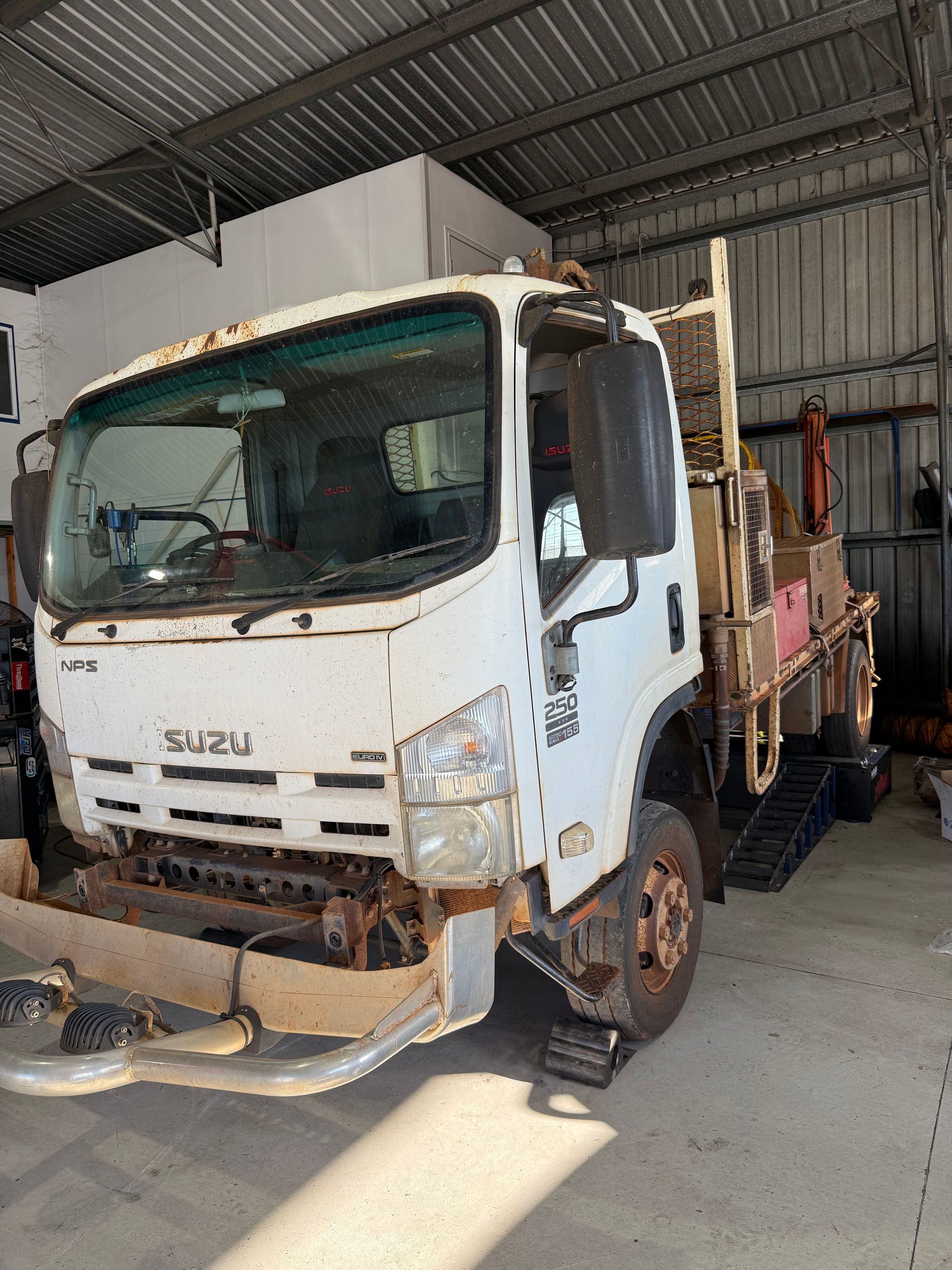 White Isuzu Truck in a Garage; Front End Damaged — Track N Back 4x4 In Mareeba, QLD