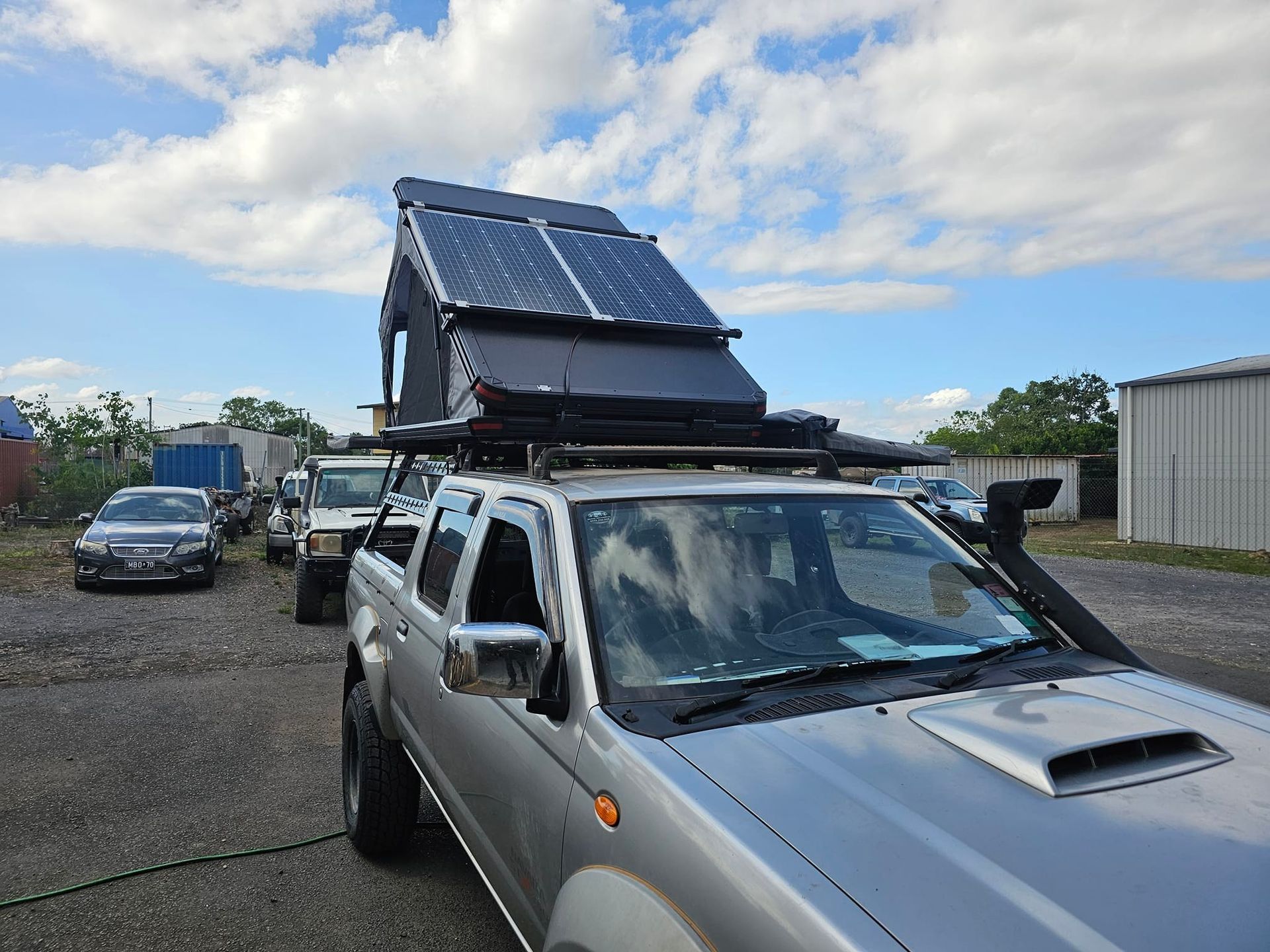 Black pickup truck with a custom cargo area and attached trailer parked outside — Track N Back 4x4 In Mareeba, QLD