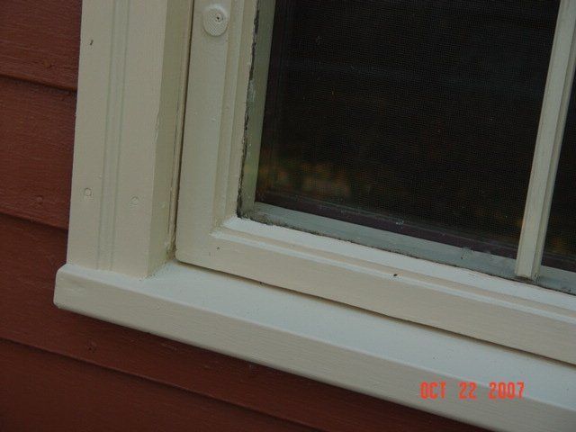 White-framed window in a red-sided exterior wall