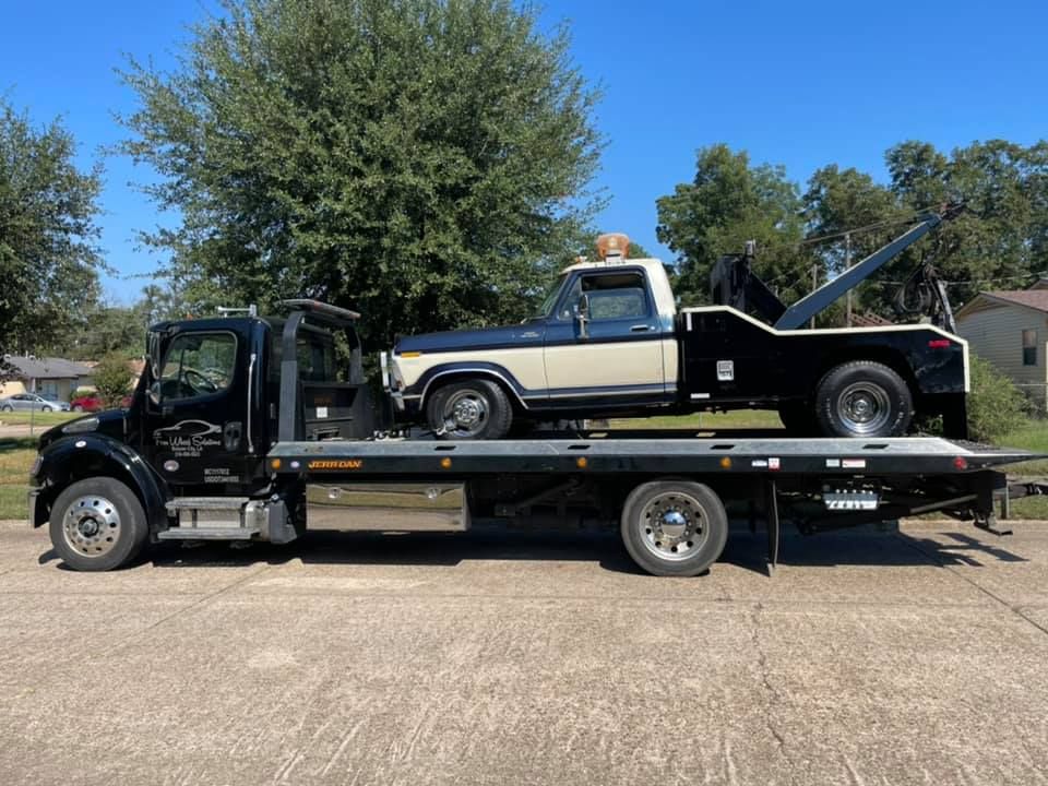 A tow truck with a car on the back of it.