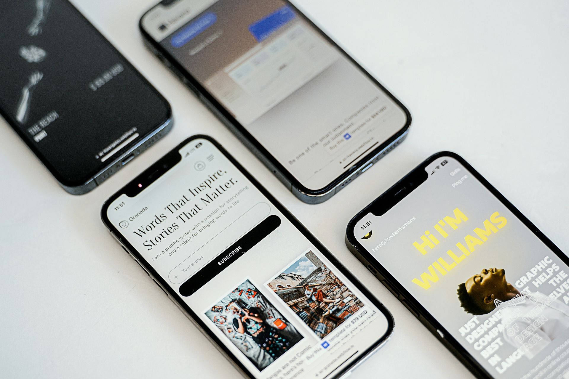 Quatre smartphones affichant différentes pages Web sur une surface blanche.