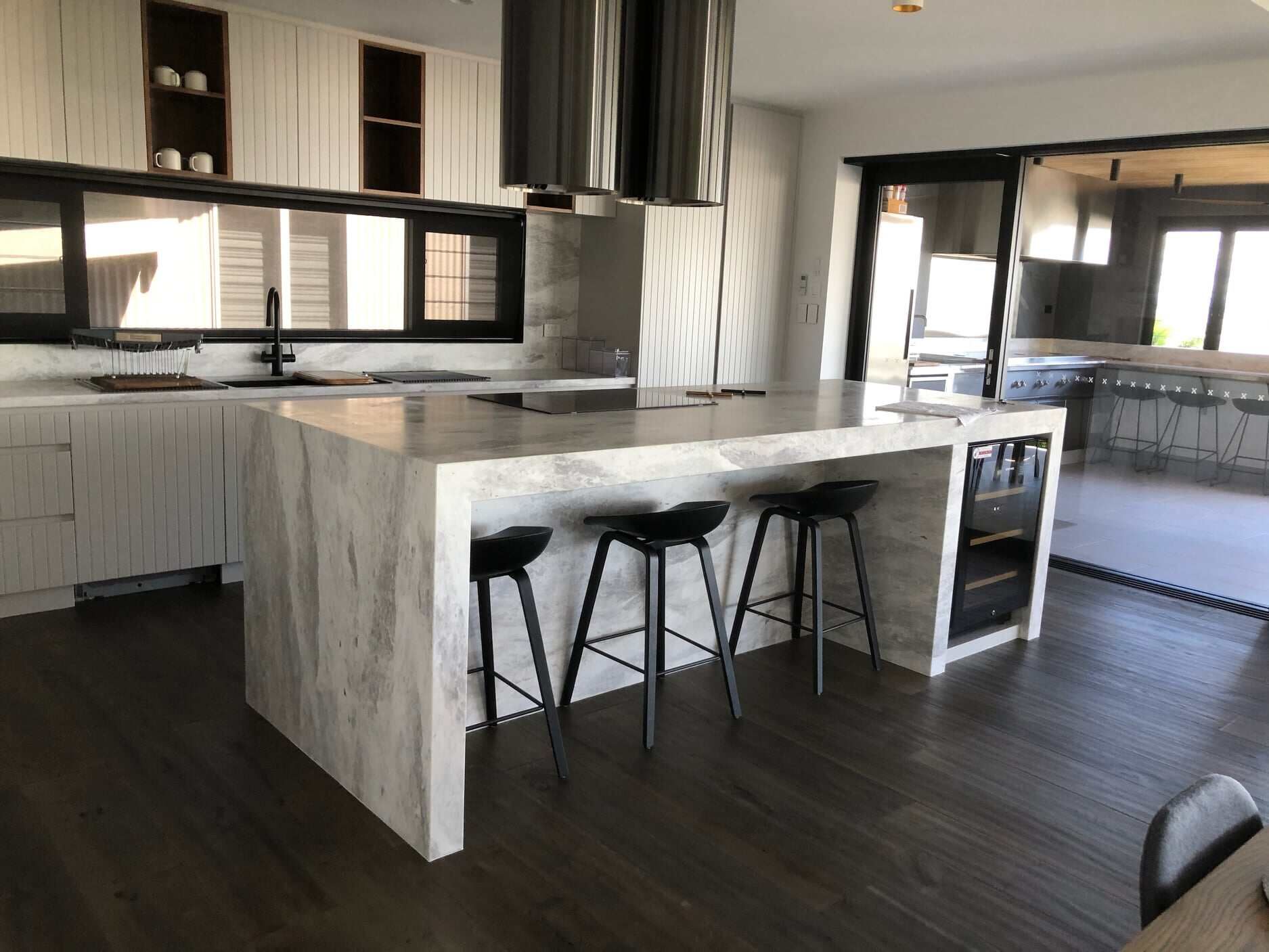 A Kitchen With a Large Island and Stools — Regalline Cabinets & Joinery in Svensson Heights, QLD