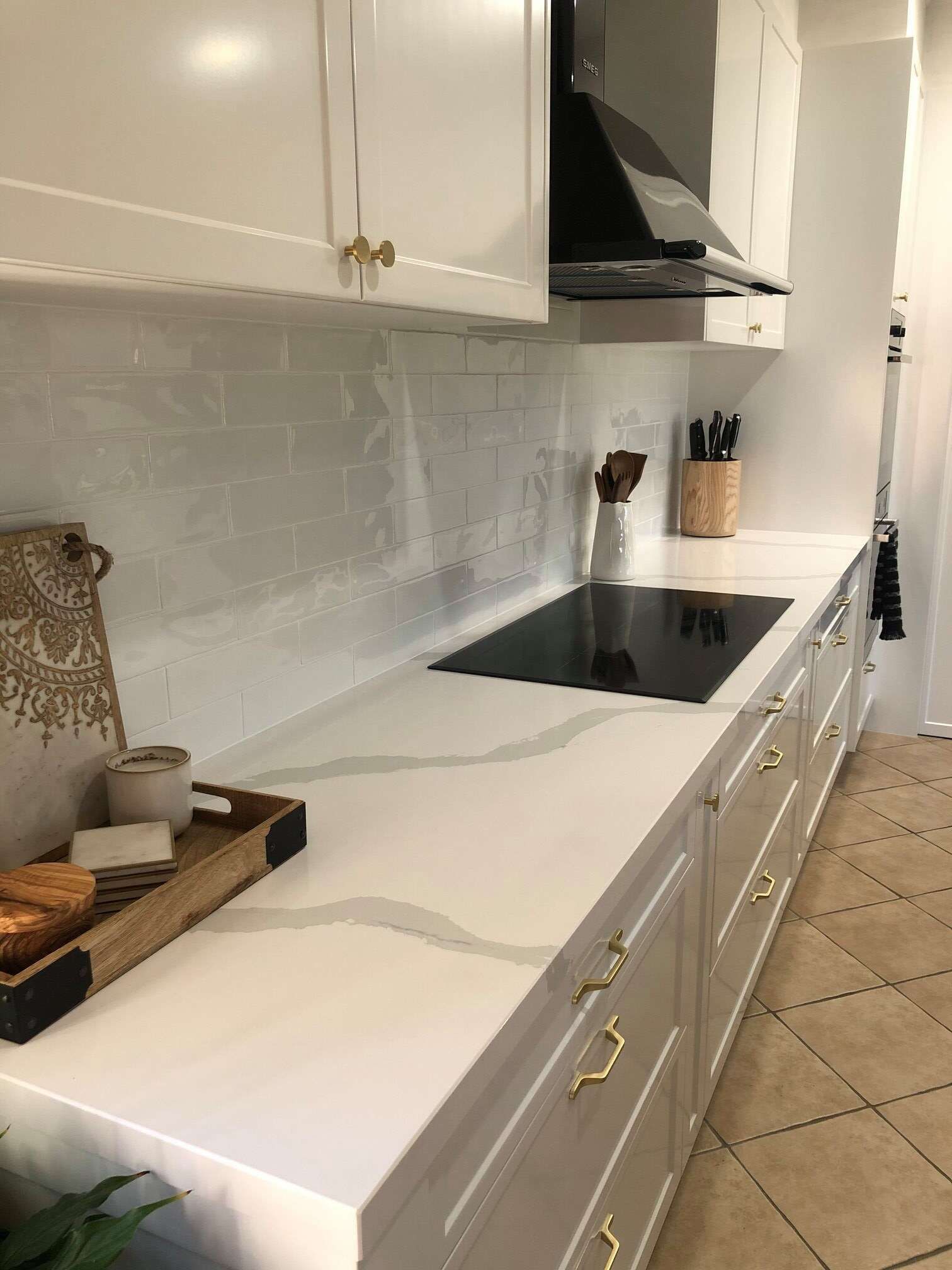 A Kitchen With White Cabinets and a Black Stove Top Oven — Regalline Cabinets & Joinery in Svensson Heights, QLD