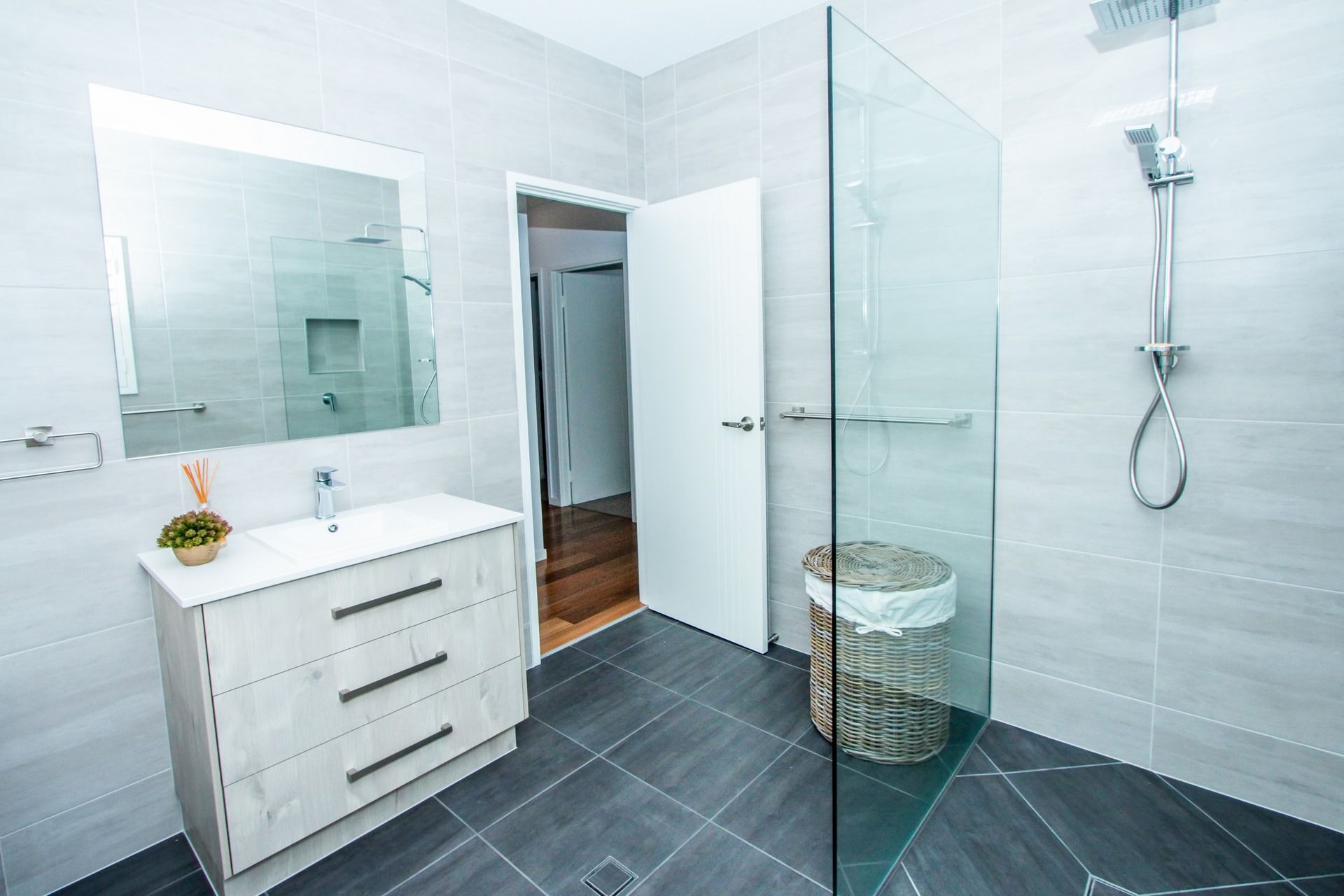 A Bathroom With a Toilet, Sink, Mirror and Window — Regalline Cabinets & Joinery in Svensson Heights, QLD