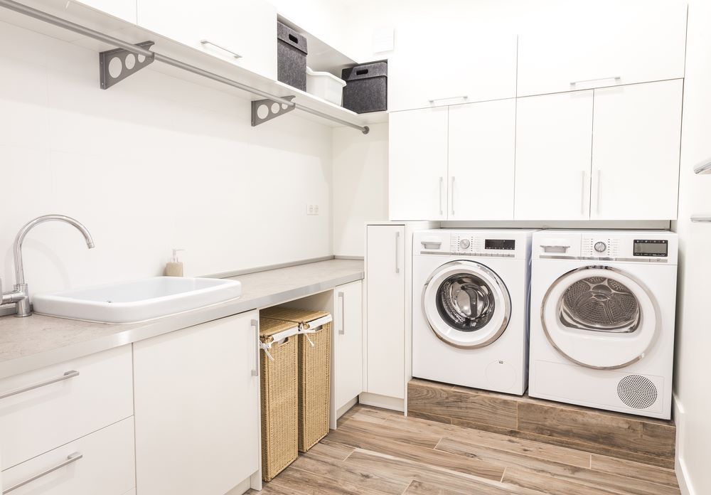 A Laundry Room With Two Washers and Two Dryers — Regalline Cabinets & Joinery in Svensson Heights, QLD