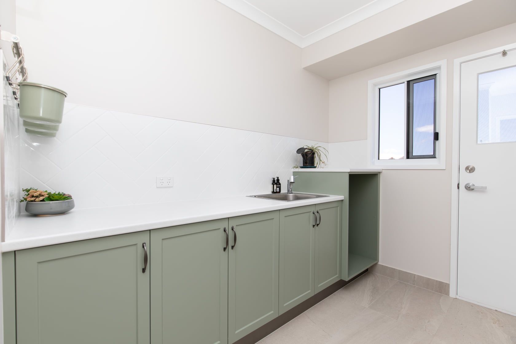 A Kitchen With Green Cabinets, a Sink, and a Window — Regalline Cabinets & Joinery in Svensson Heights, QLD