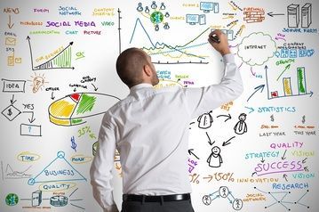 A man is writing on a white board with a marker