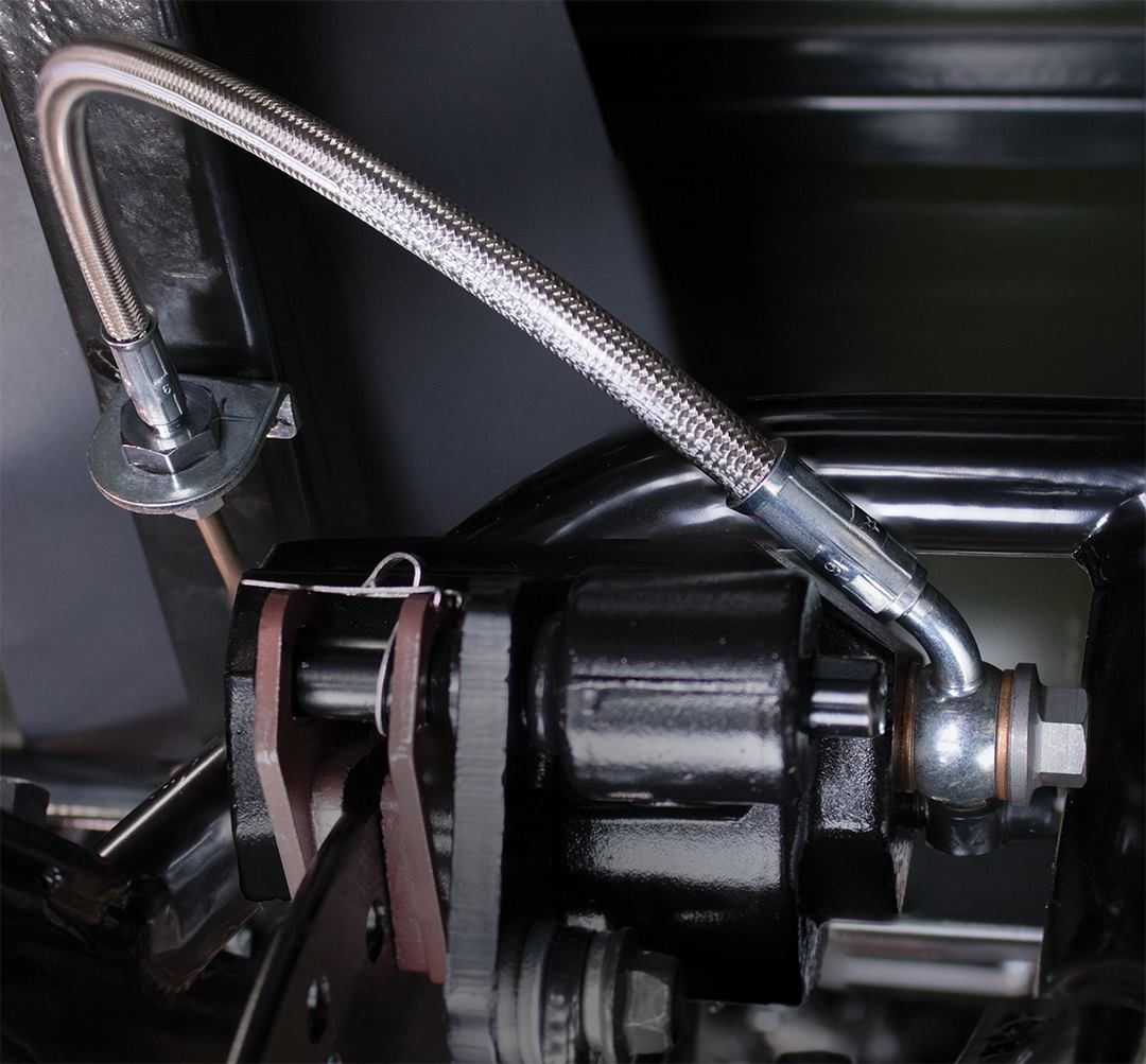 Made to order hoses with metal connectors on a wooden workbench, shop background.