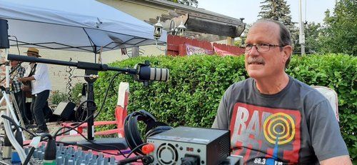 A man is sitting at a table with a microphone in front of him.