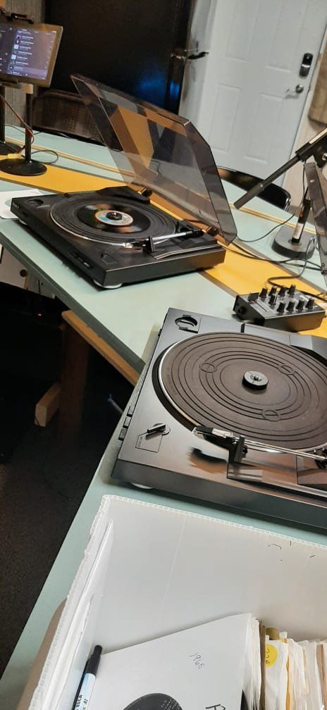 Two record players are sitting on a table.