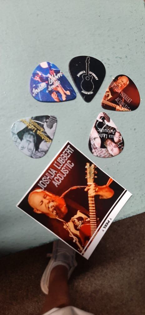 A person is holding a guitar pick next to a guitar string