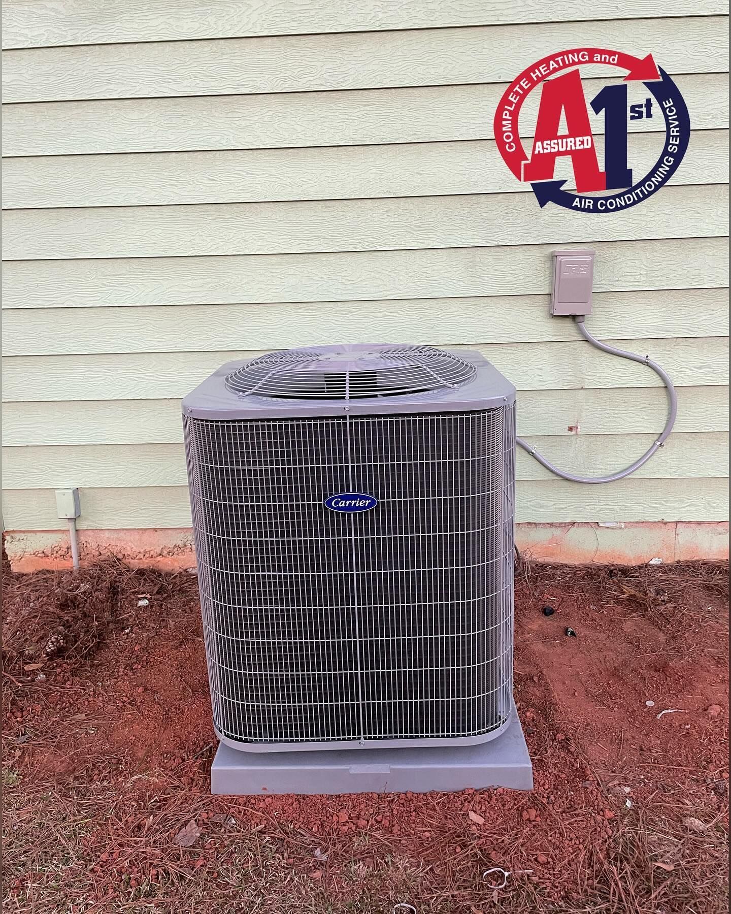 HVAC unit outside against a light brown wall, logo of A1 Complete Heating, on a concrete pad.