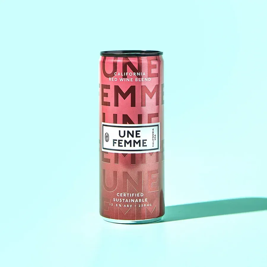 Pink cannabis drink can labeled “Uner Femme” on a light blue background.