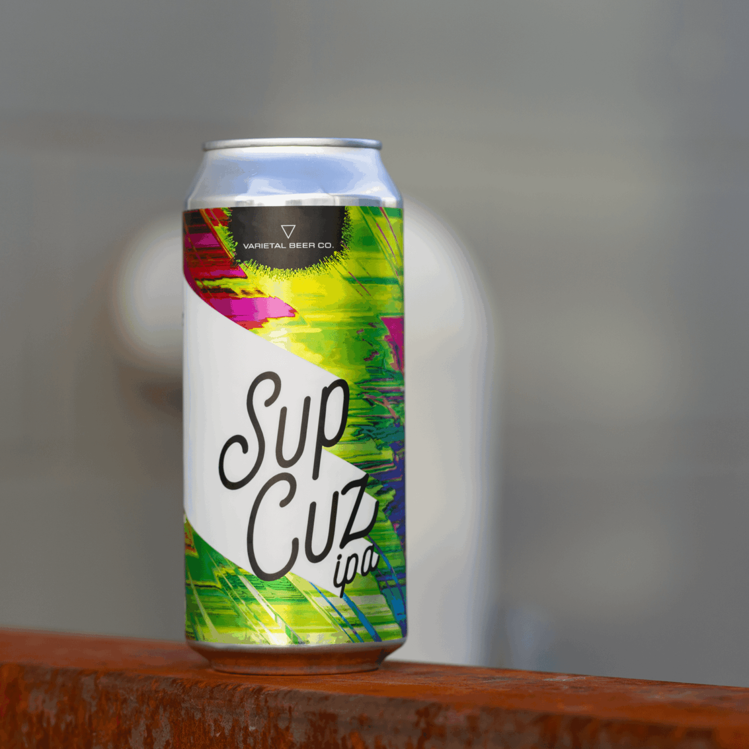 Colorful Suu Cuu can with neon green, pink, and yellow label on a wooden surface.