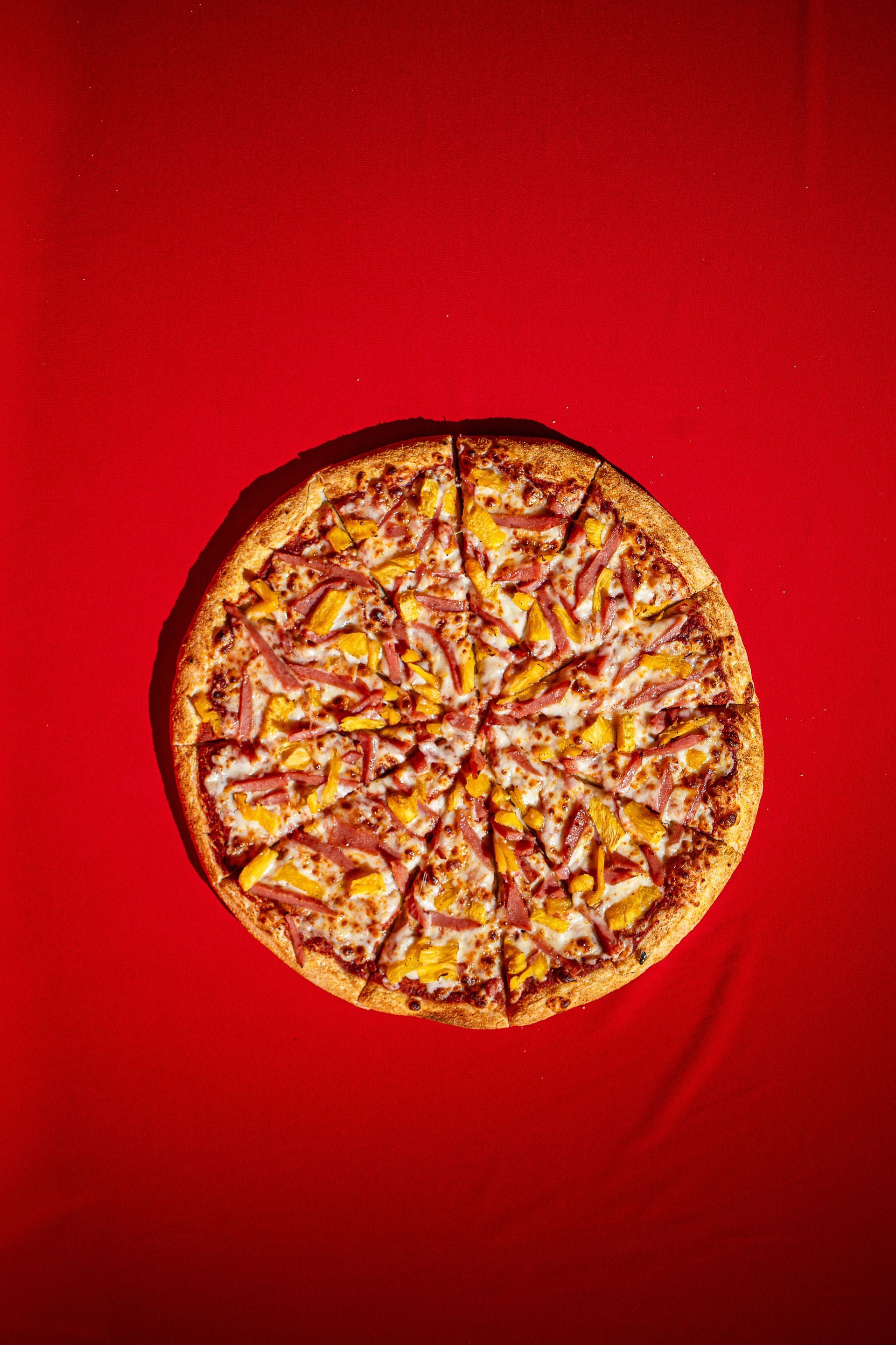 Round pizza on a bright red background, centered in frame.