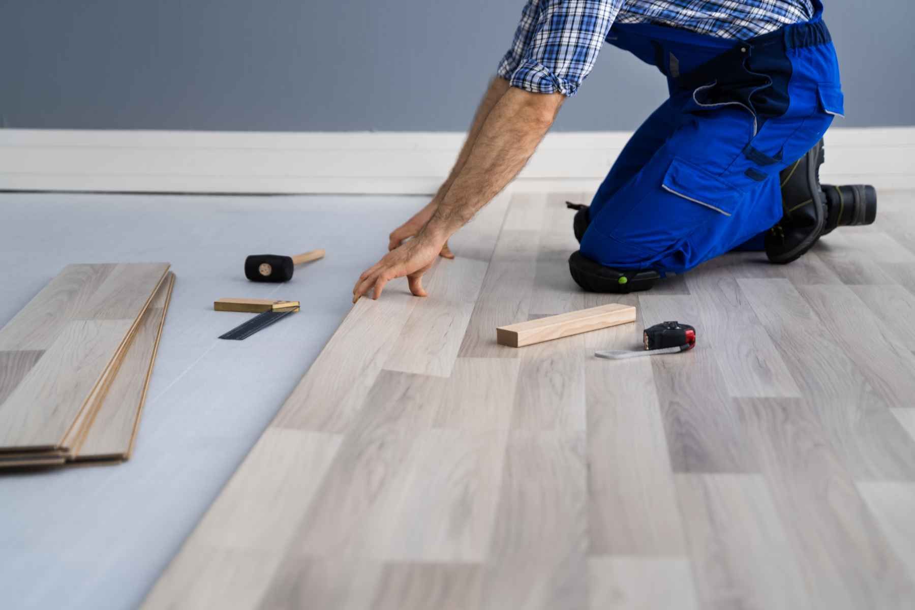 carpintero instalando suelo laminado