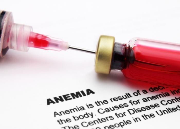 Jeringa extrayendo líquido rojo de un vial junto a la palabra