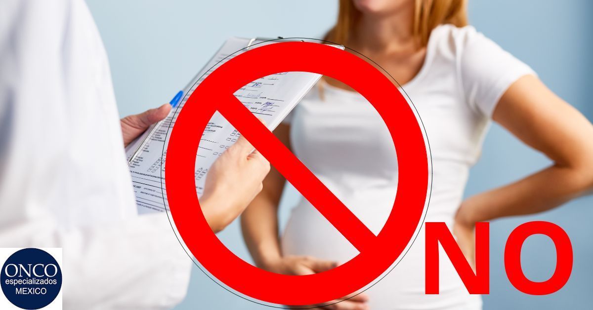 Una mujer está parada frente a una señal de prohibido