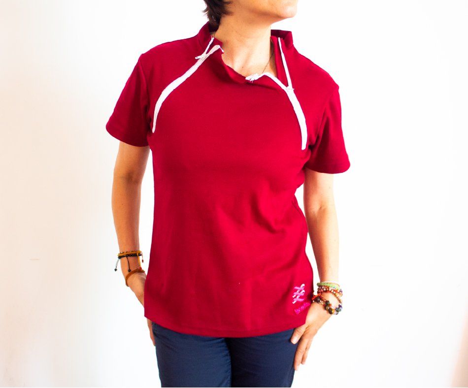 A woman is wearing a red shirt with a white zipper