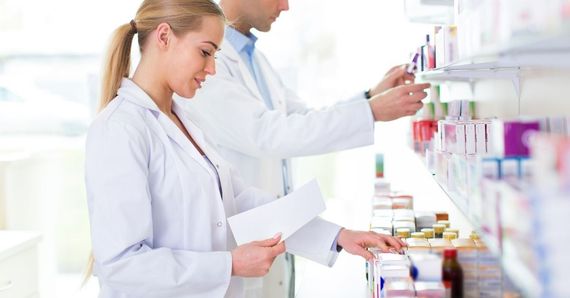 medicamento pedido Científicos con batas de laboratorio revisan muestras y documentos en una estantería iluminada del laboratorio.