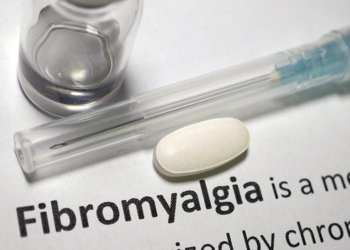 Jeringa, pastilla y vial en una página que dice “Fibromialgia”.