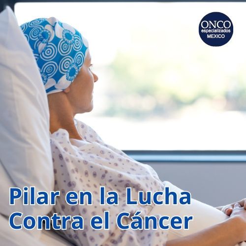 Paciente con pañuelo en la cabeza, sentada junto a una ventana, representando la lucha contra el cáncer.