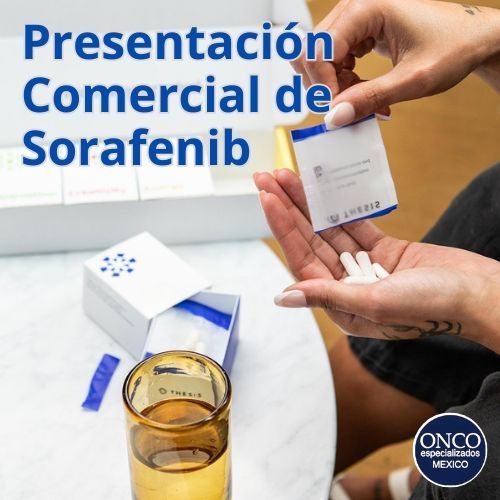 Persona mostrando cápsulas de Sorafenib junto a vaso con agua.
