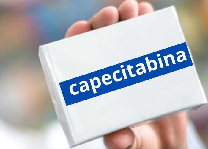 Una persona sostiene una caja de capecitabina en la mano.