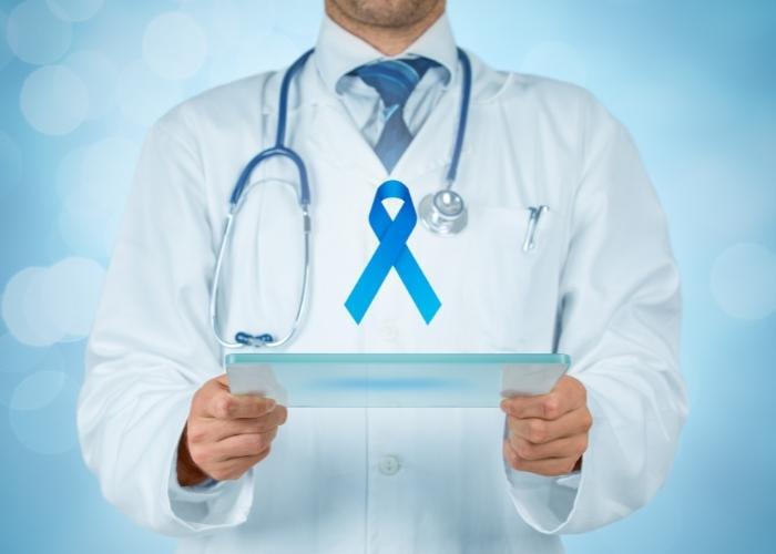 Un médico sostiene una placa de vidrio con una cinta azul de concienciación en un entorno clínico.