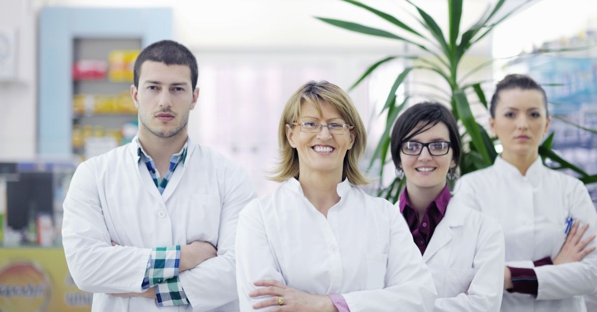 Un grupo de farmacéuticos posa para una fotografía en una farmacia.