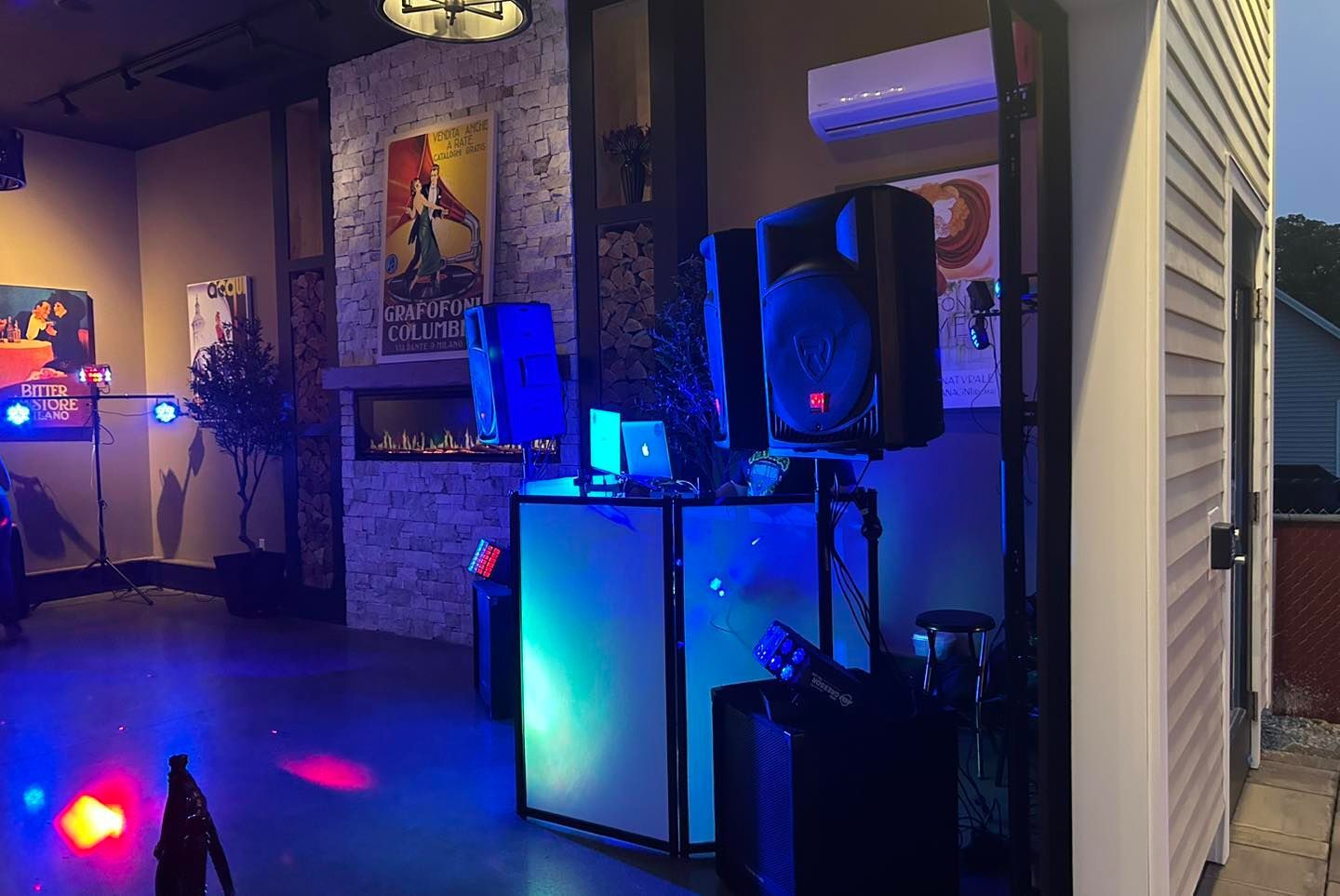A dj booth is set up in a room with a dance floor.