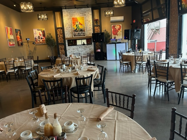 A large room with tables and chairs set up for a wedding reception.