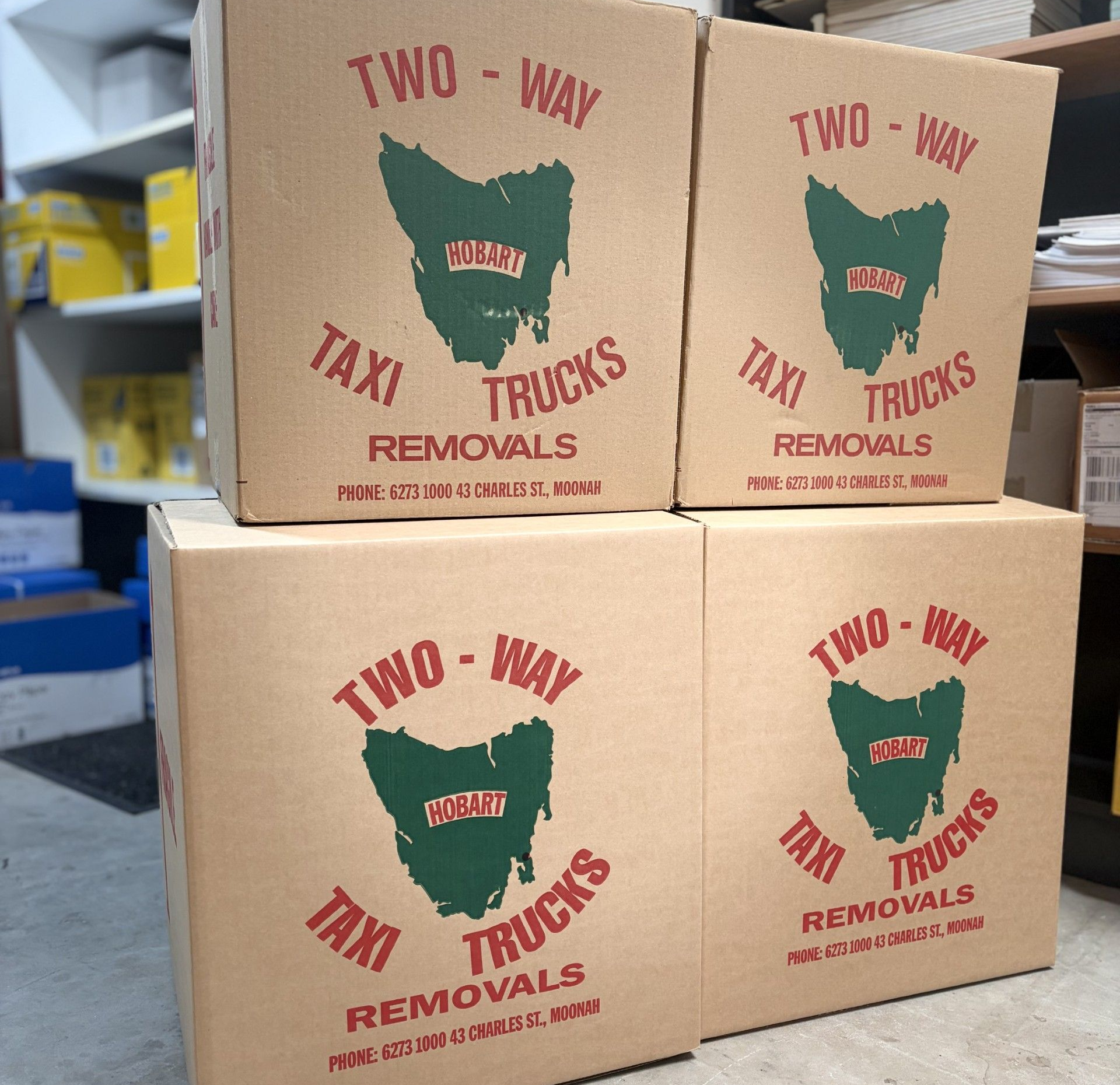Four cardboard boxes stacked, each labeled 