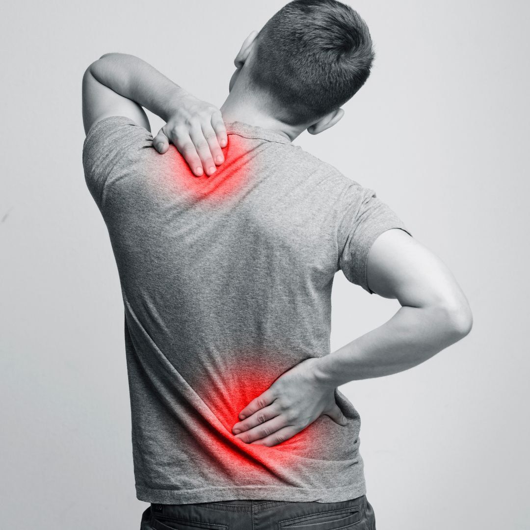 A man is holding his neck and back in pain.