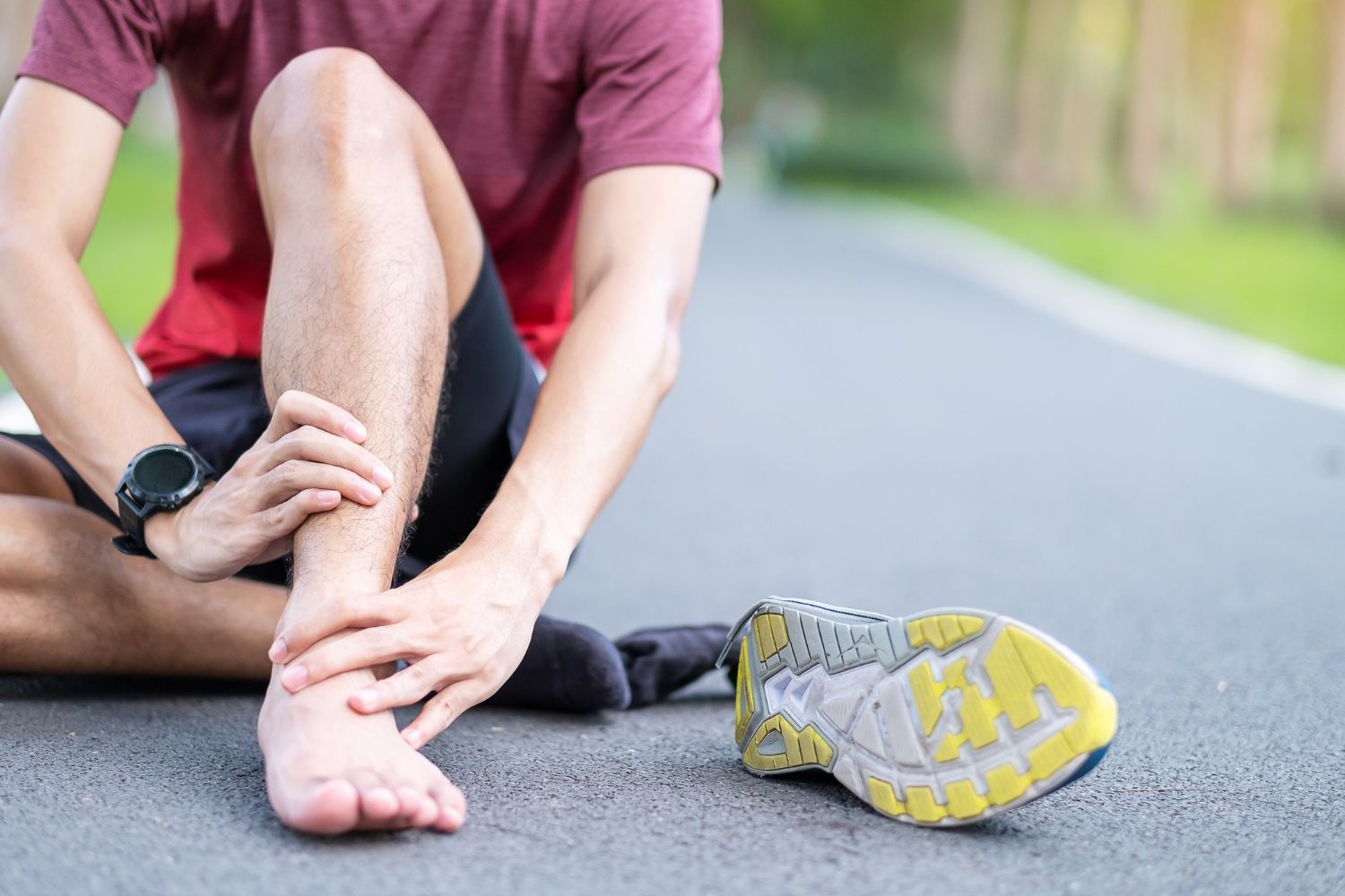 Essex Physiotherapist - Ankle pain treatment - image of a man holding his ankle