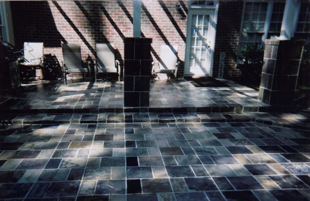 A patio with a brick building in the background