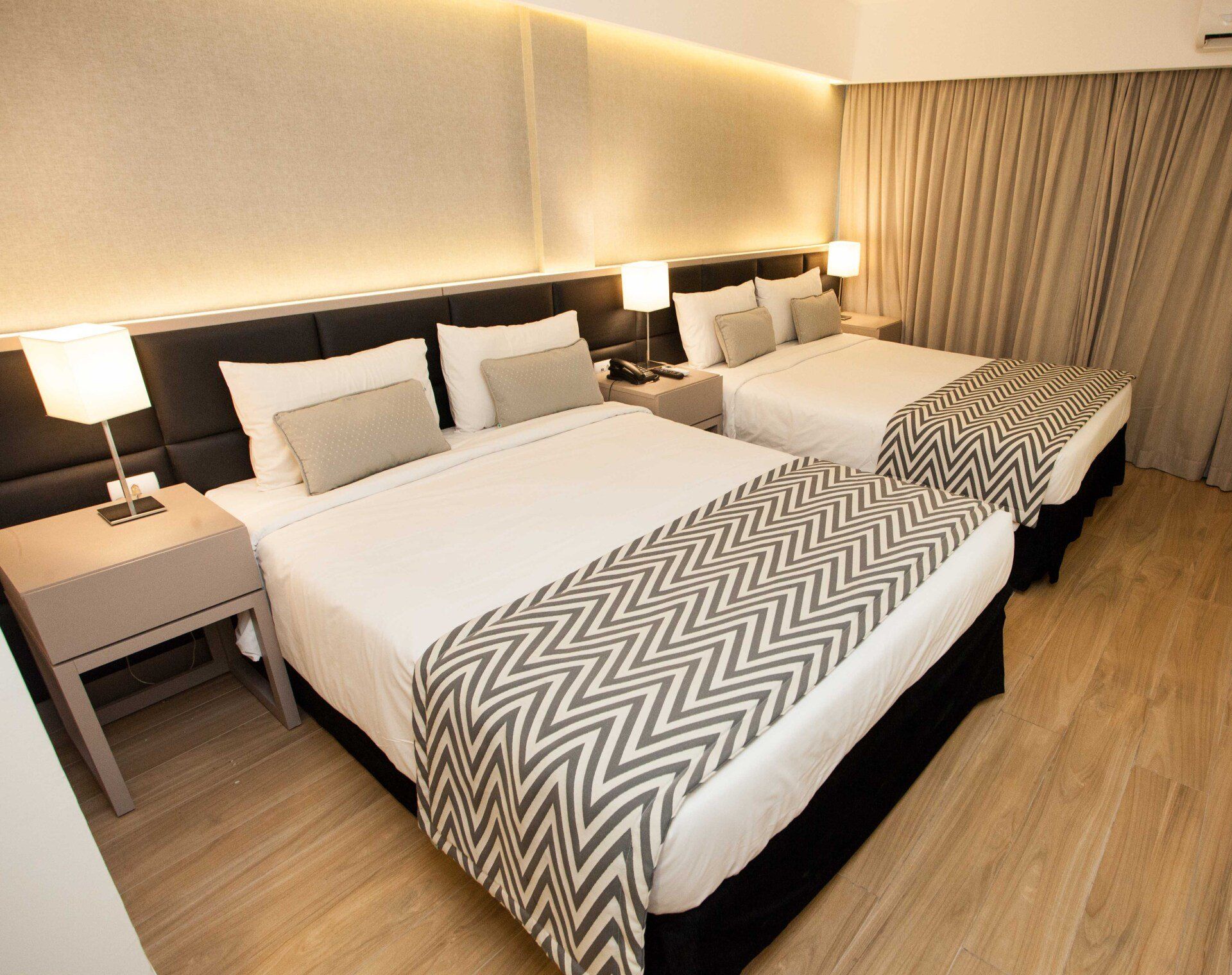 Um quarto de hotel com duas camas e uma mesa de cabeceira