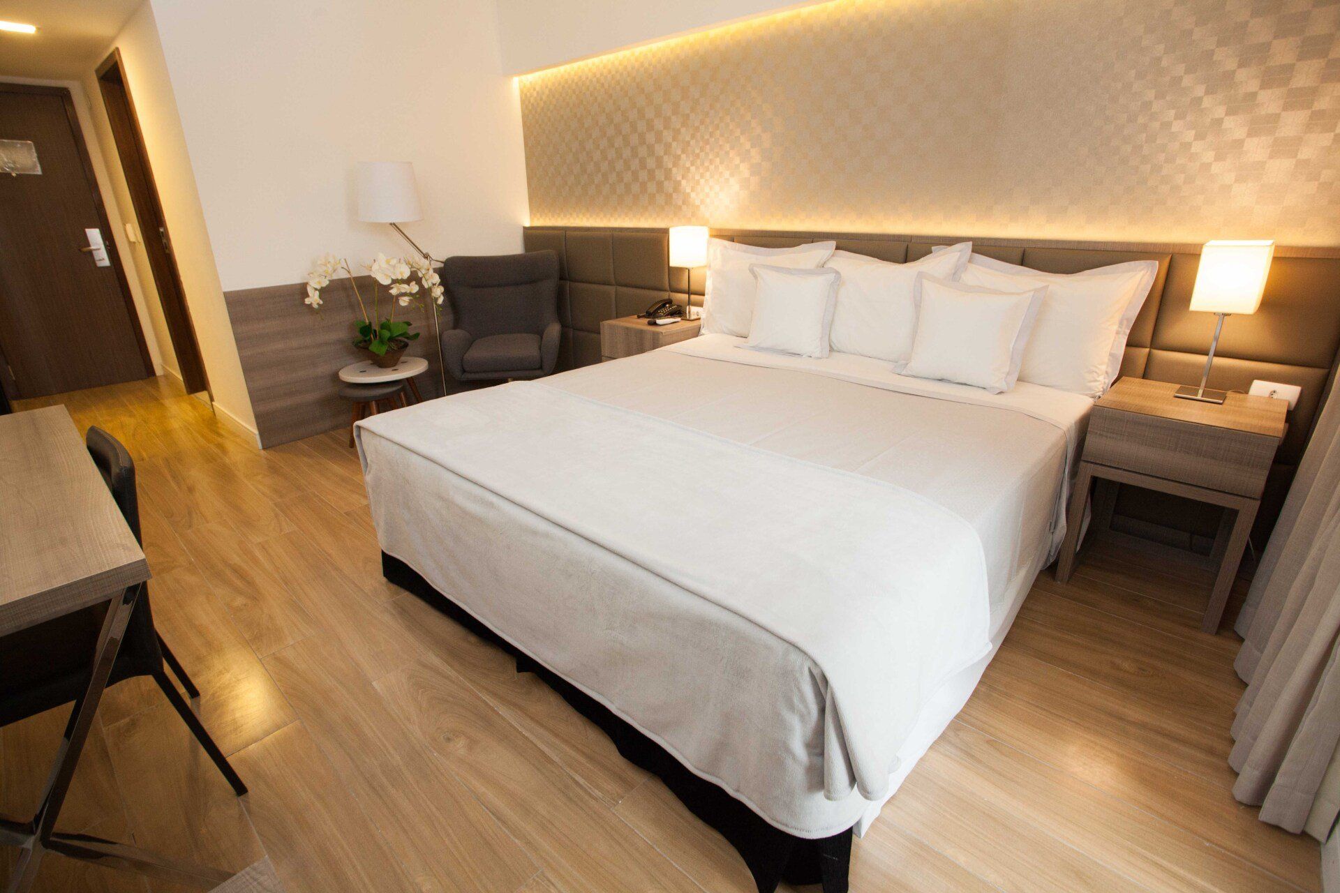 Há uma cama grande no meio do quarto.