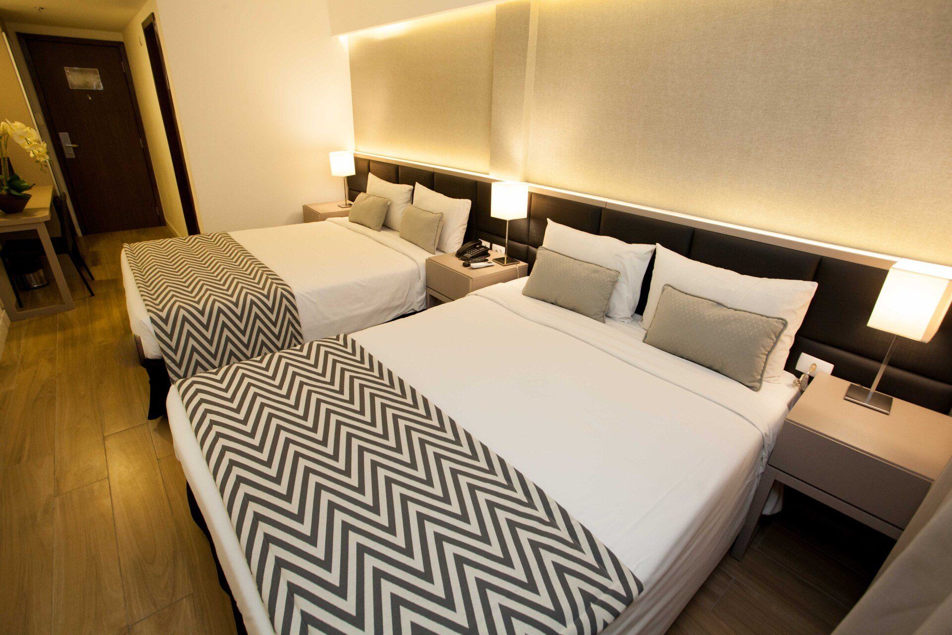 Um quarto de hotel com duas camas e uma mesa de cabeceira.