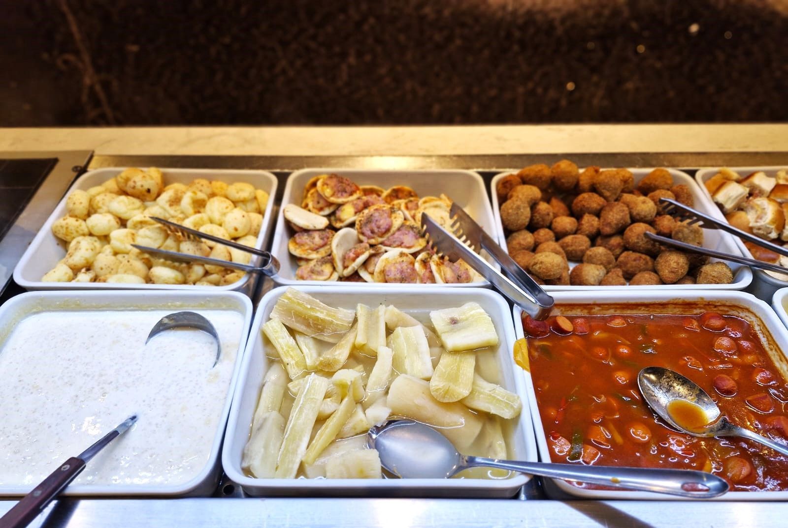 Uma linha de bufê repleta de uma variedade de alimentos e molhos