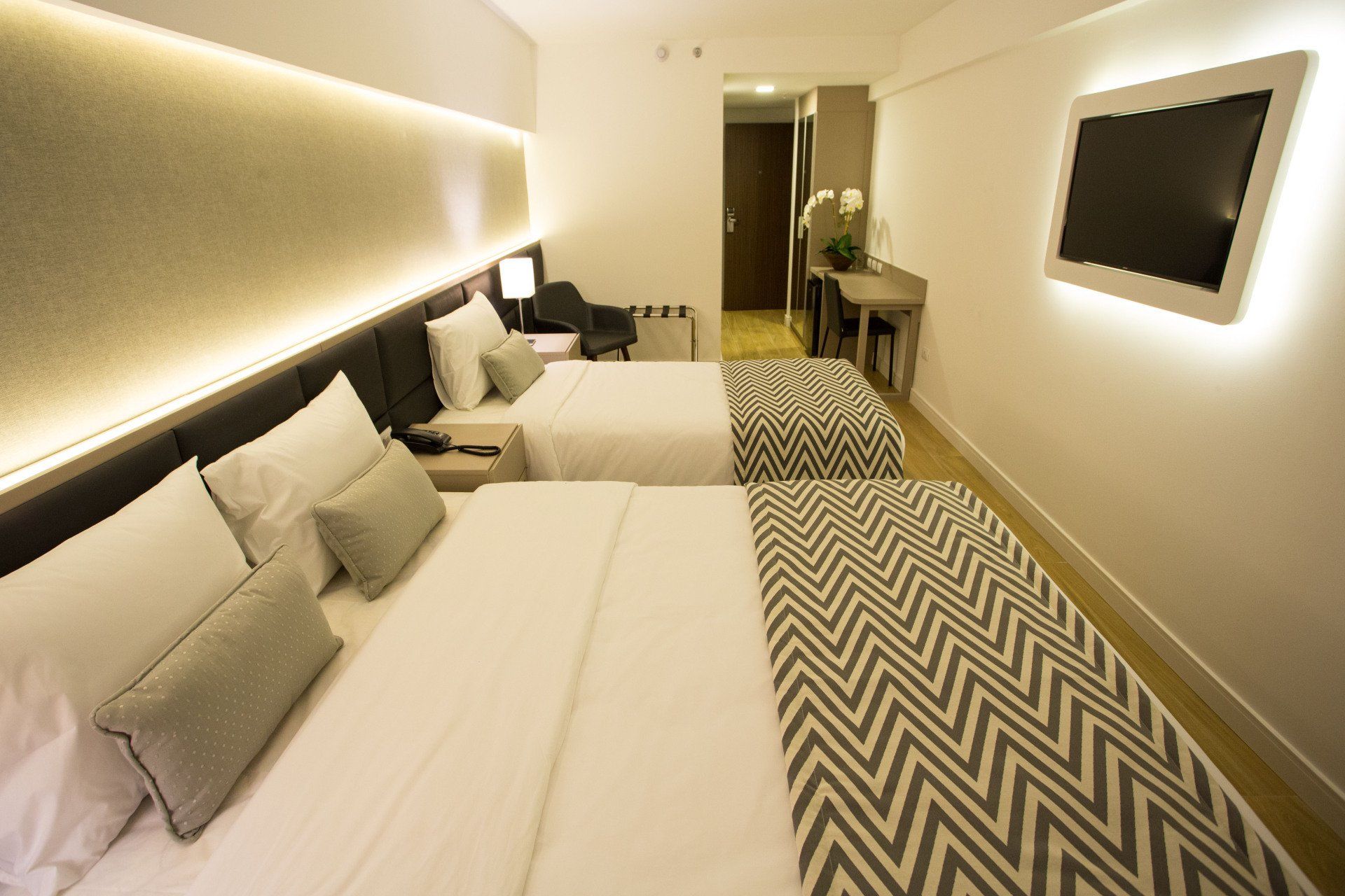 Um quarto de hotel com duas camas e uma TV de tela plana